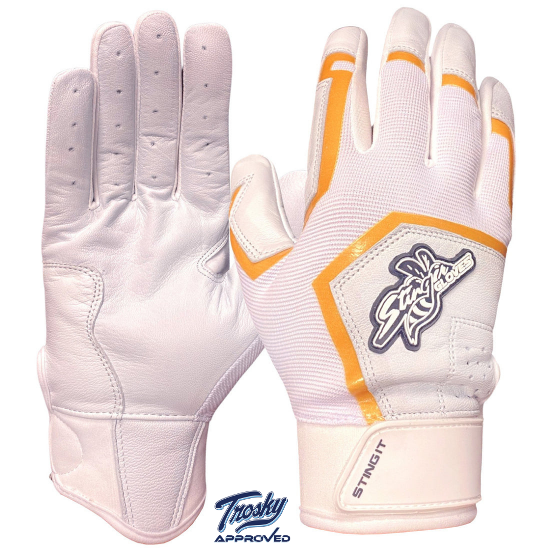 White and gold batting gloves with orange trim, showing front and back views, featuring sheepskin leather palm and mesh back with wrist closure.