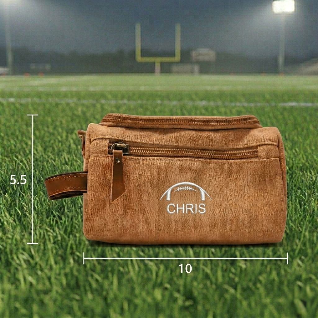 Personalized football toiletry bag in washed canvas with a leather handle and an embroidered football with custom initials, built for road games and college