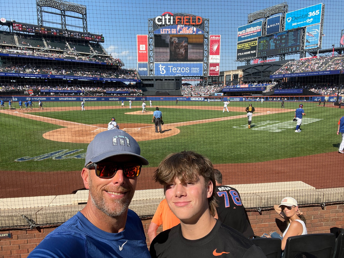 Chris Bajda and his son Tobey together in the stands at a Major League ballgame, the father and son who run Batter Box Sports