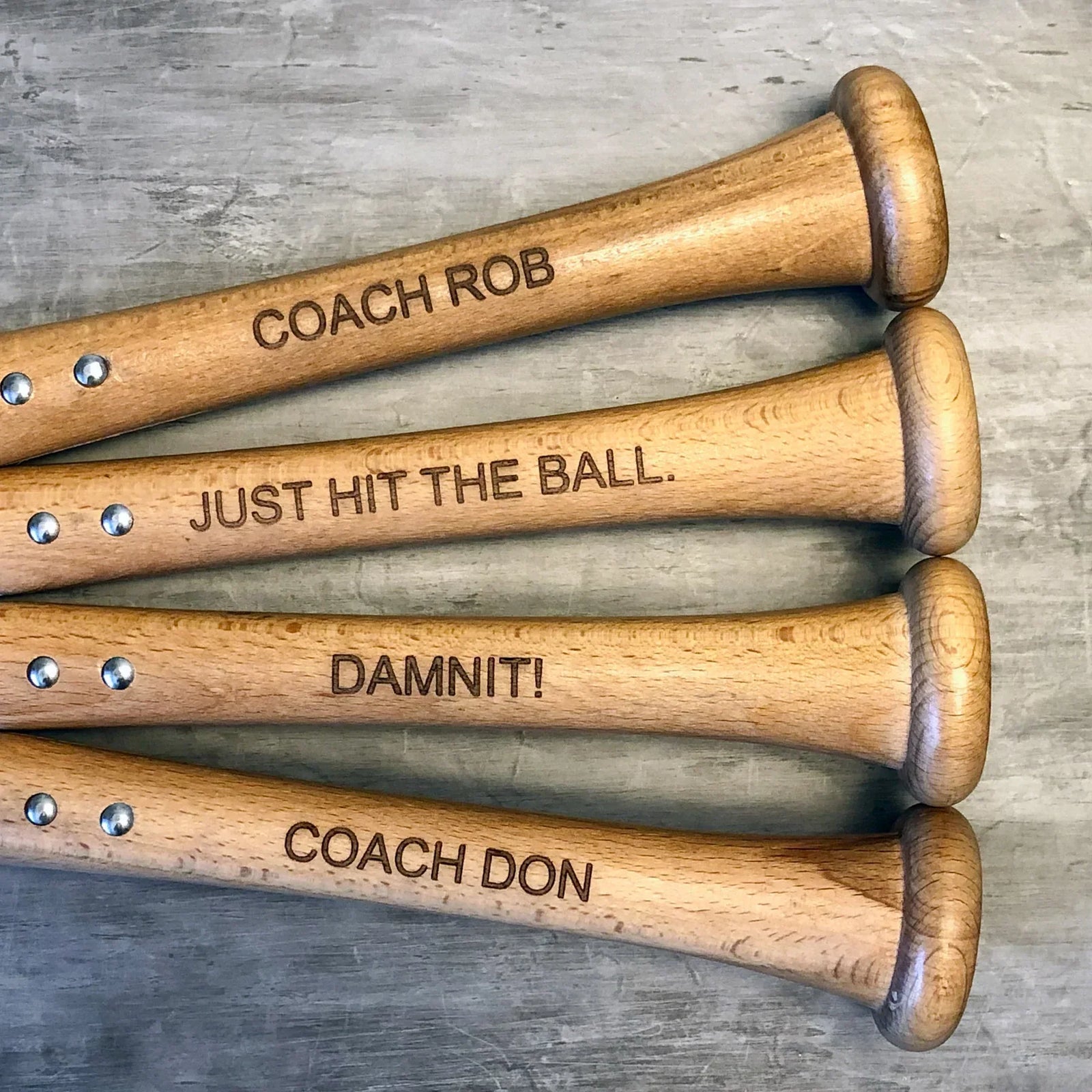 Personalized Baseball Bat Bottle Opener shown opening a bottle