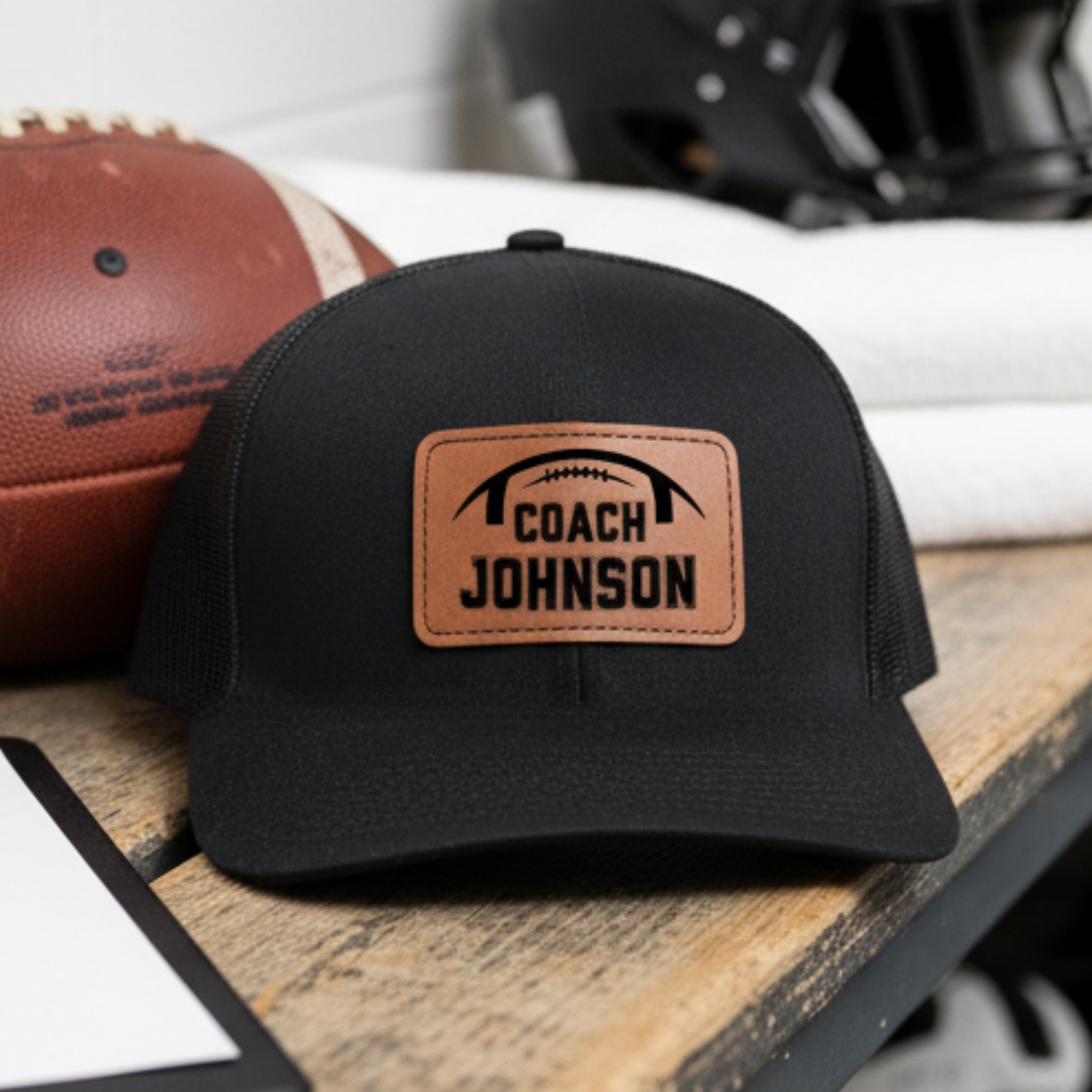 Personalized football coach leather patch hat with a football and the coach's name laser-engraved into a real leather patch on a structured snapback cap