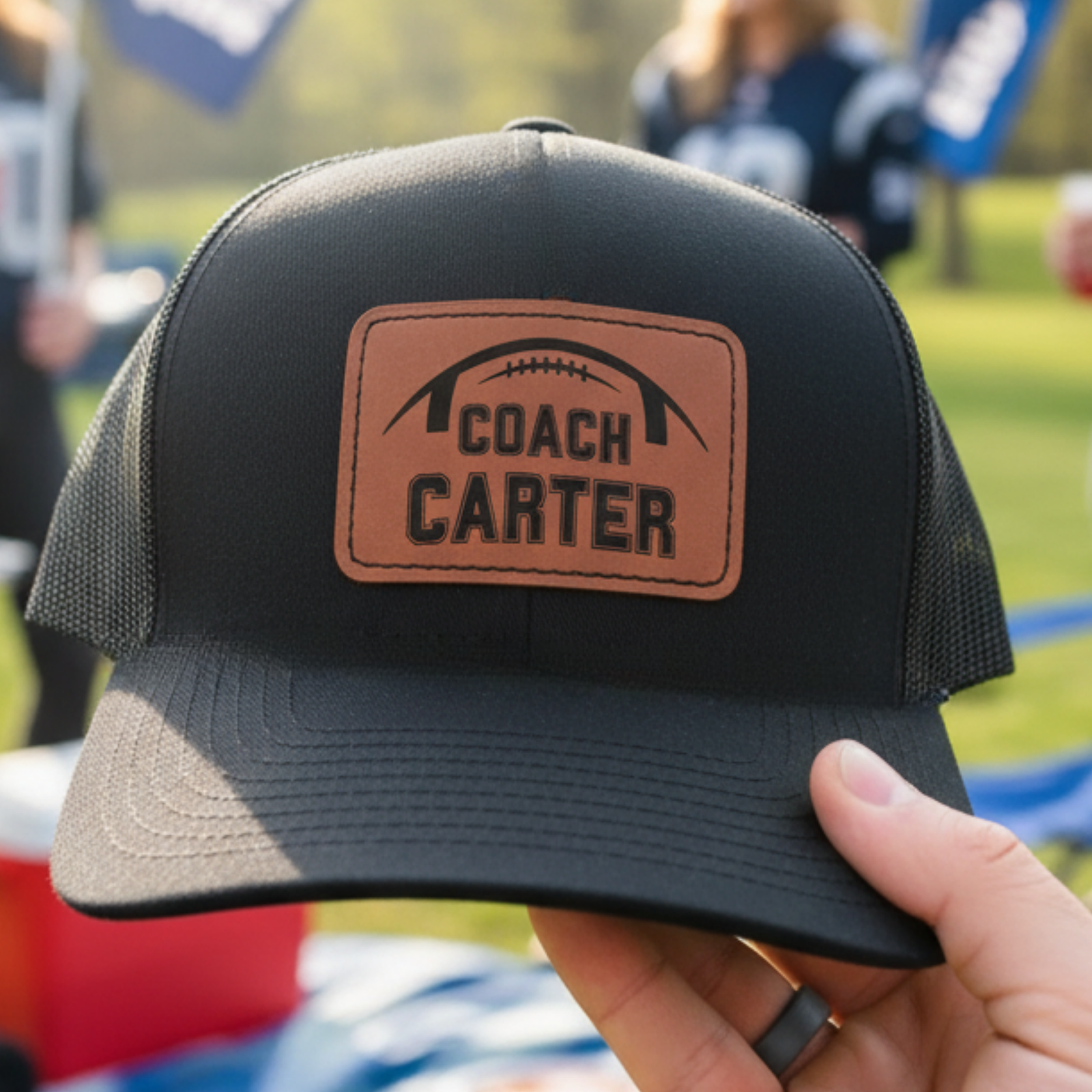 Personalized football coach leather patch hat with a football and the coach's name laser-engraved into a real leather patch on a structured snapback cap