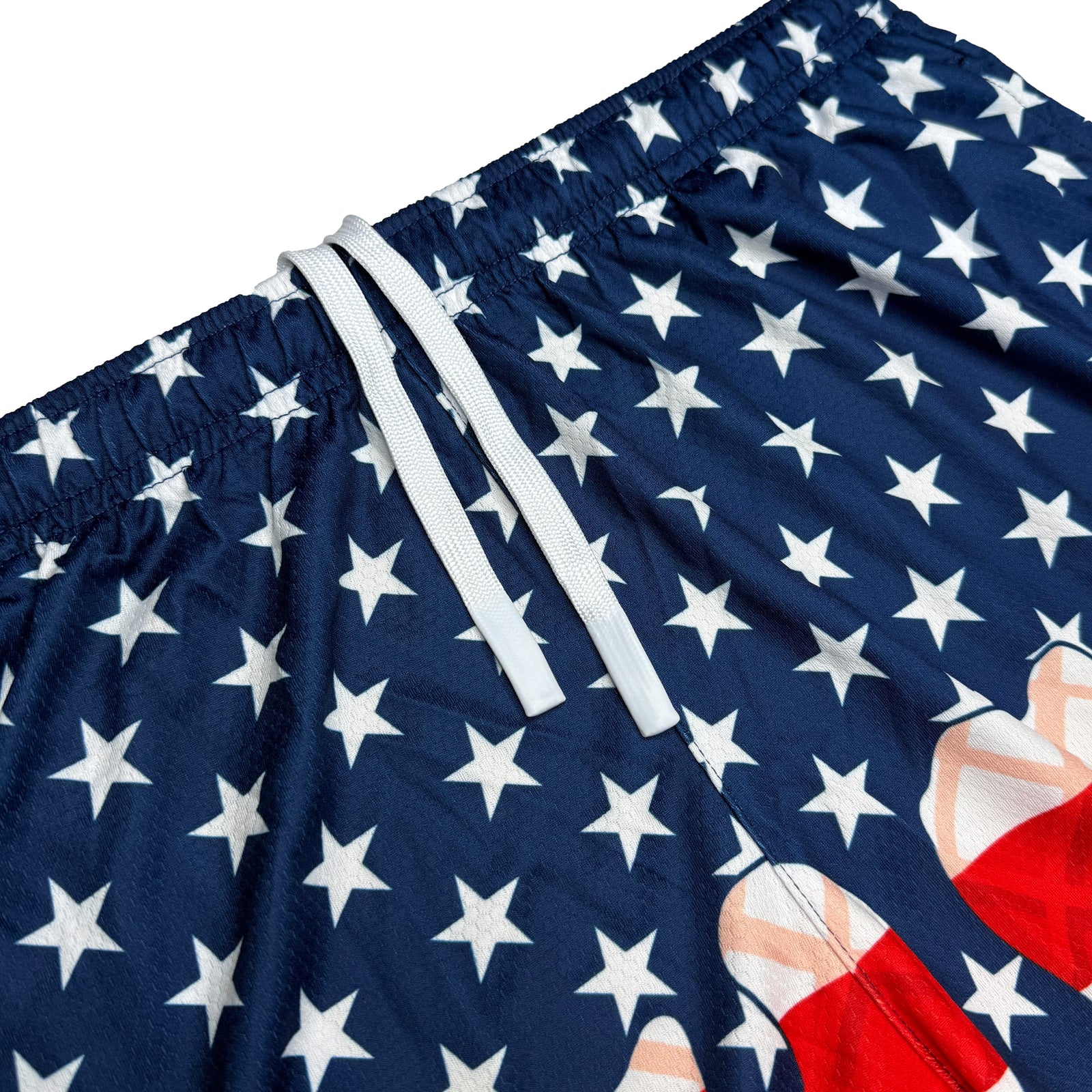 Navy shorts with white stars and red stripe pattern, showing elastic waistband with white drawstrings and deep side pocket detail