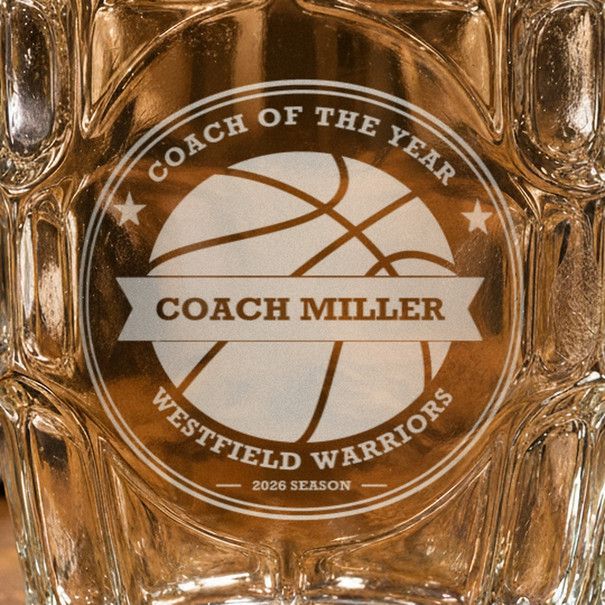 Close-up of the frosted laser engraving on the basketball coach stein, showing the basketball crest, the Coach Miller banner and the team name arc