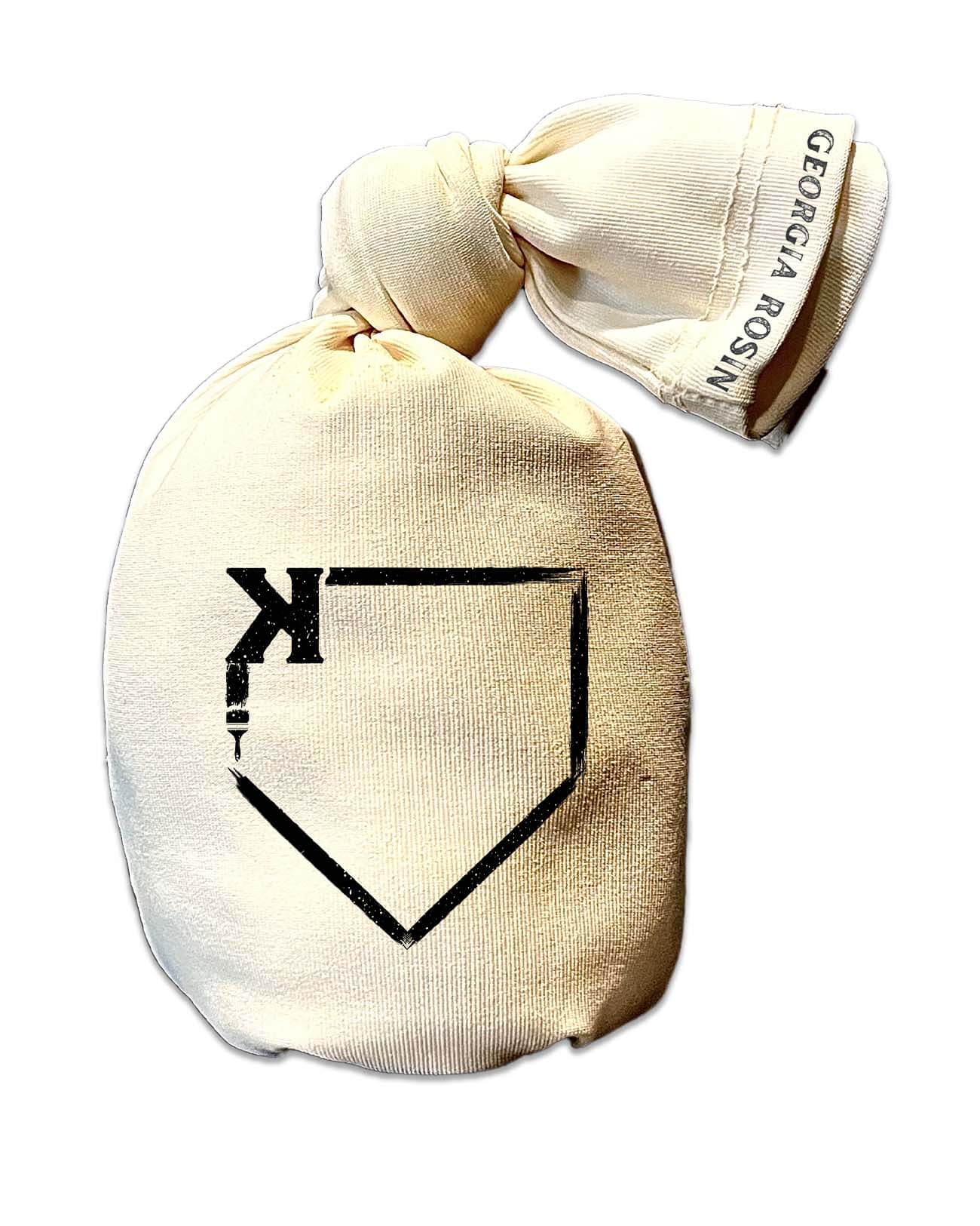 Cream-colored rosin bag with black home plate and pitcher graphic, displayed with included storage bag featuring "Georgia Rosin" text on the ribbon closure