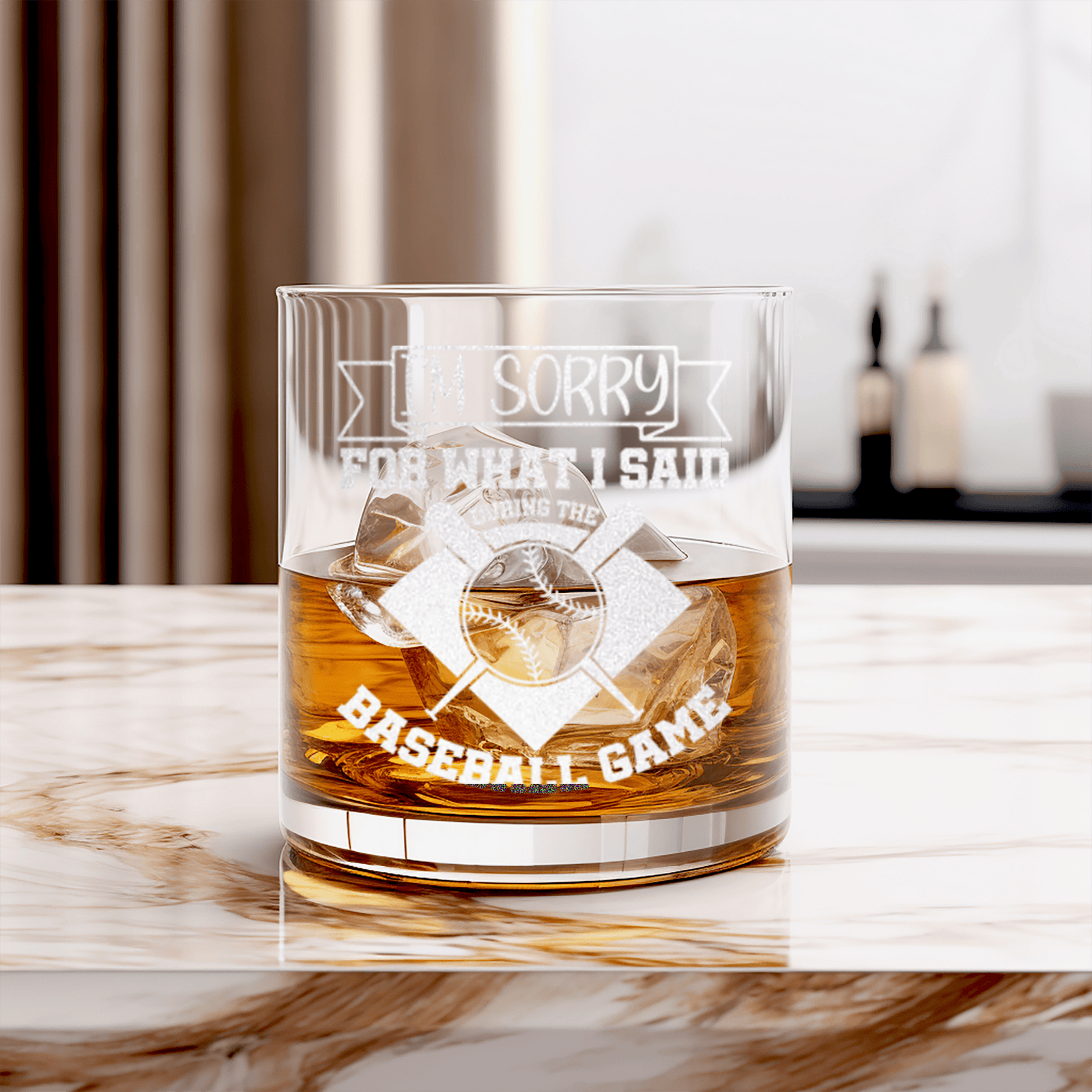 Whiskey rocks glass with the 'I'm Sorry For What I Said During The Baseball Game' engraving filled with whiskey and ice on a marble countertop