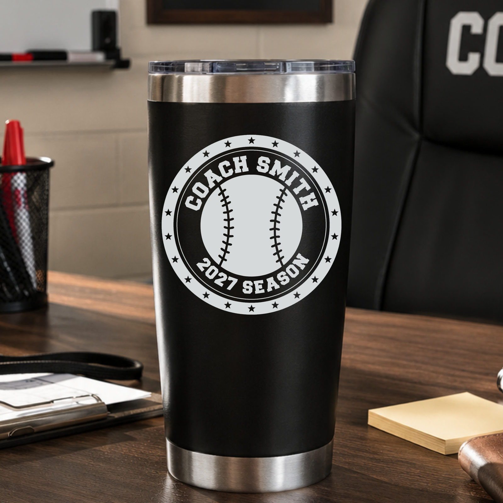 Baseball coach tumbler engraved with COACH SMITH and 2027 SEASON on a coach's desk, a personalized end-of-season gift