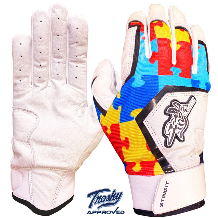 Batting gloves with white sheepskin leather palm and colorful puzzle-piece patterned back in red, blue, and yellow, featuring brand logos on the cuff and wrist strap.