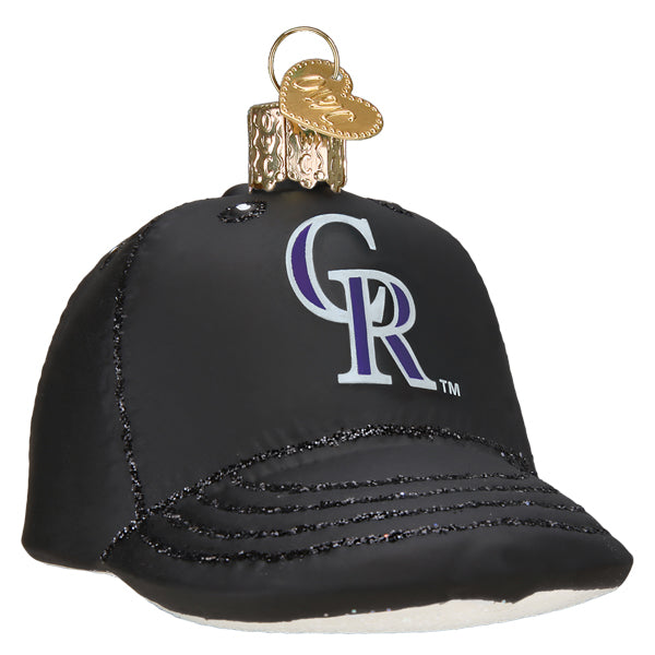 Black baseball cap ornament with purple and silver Rockies "CR" logo and glittered visor detail, topped with brass baseball cap charm and hanging loop
