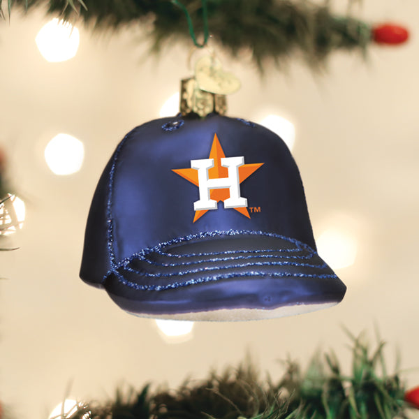 Navy Houston Astros glass baseball-cap ornament with the orange-and-white H-and-star logo, hung on a lit Christmas tree