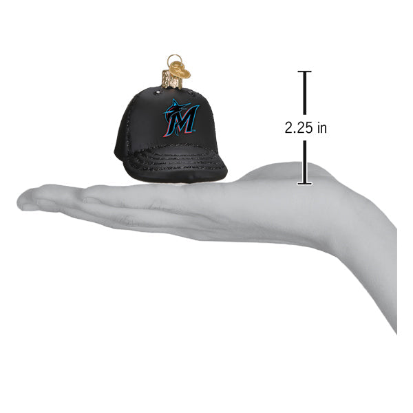Black baseball cap ornament with teal Marlins logo, shown in hand with 2.25-inch height measurement indicator