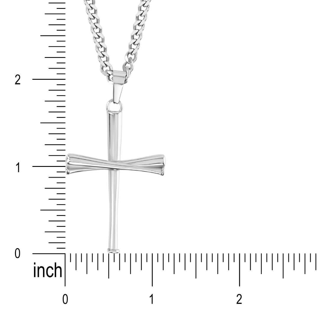 Silver baseball-bat cross pendant on a curb chain held against an inch ruler, showing the pendant measures about 1.25 inches tall