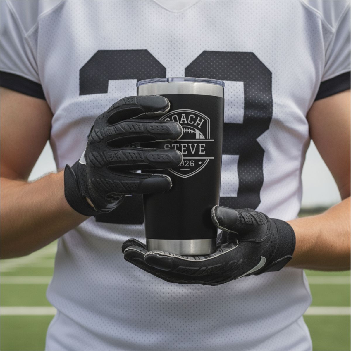 Personalized football coach tumbler with the coach's name and a football design engraved on the front and the full team roster engraved on the back