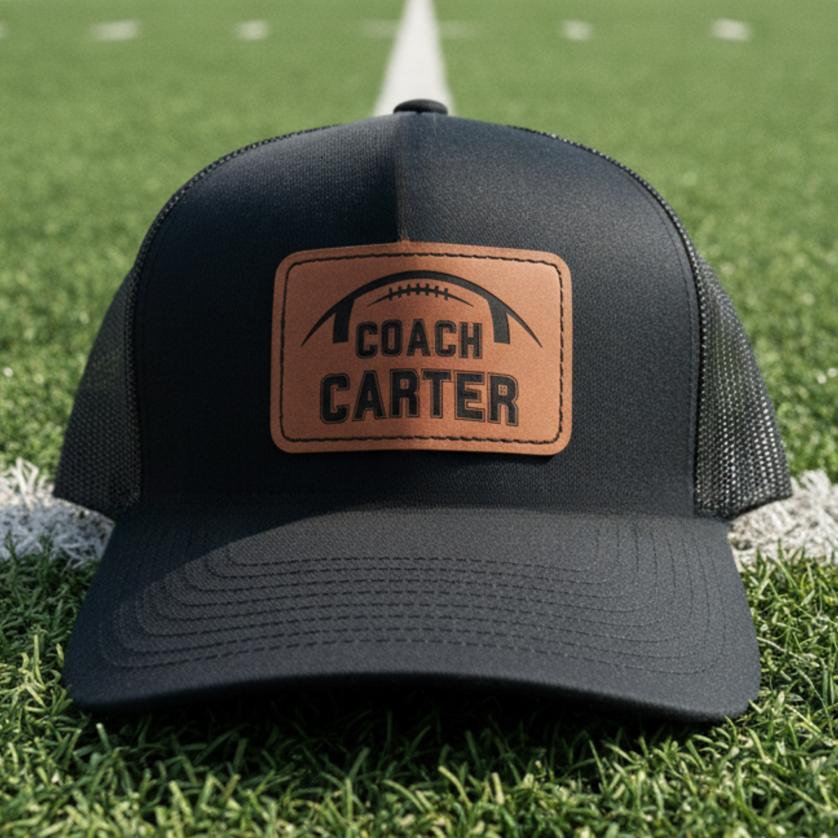 Personalized football coach leather patch hat with a football and the coach's name laser-engraved into a real leather patch on a structured snapback cap