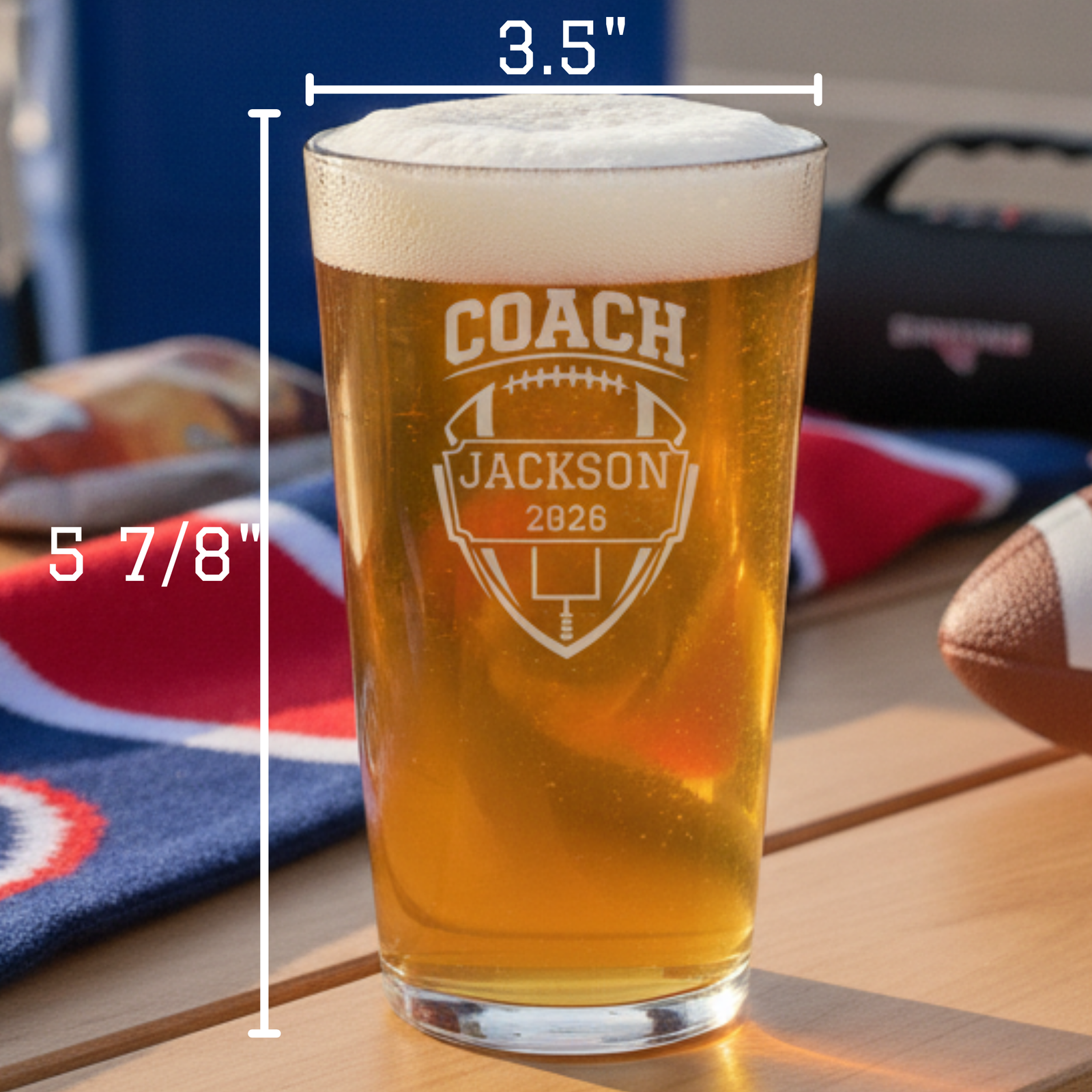 Back of the personalized football coach pint glass showing the engraved team roster with player names listed down the side of the clear glass
