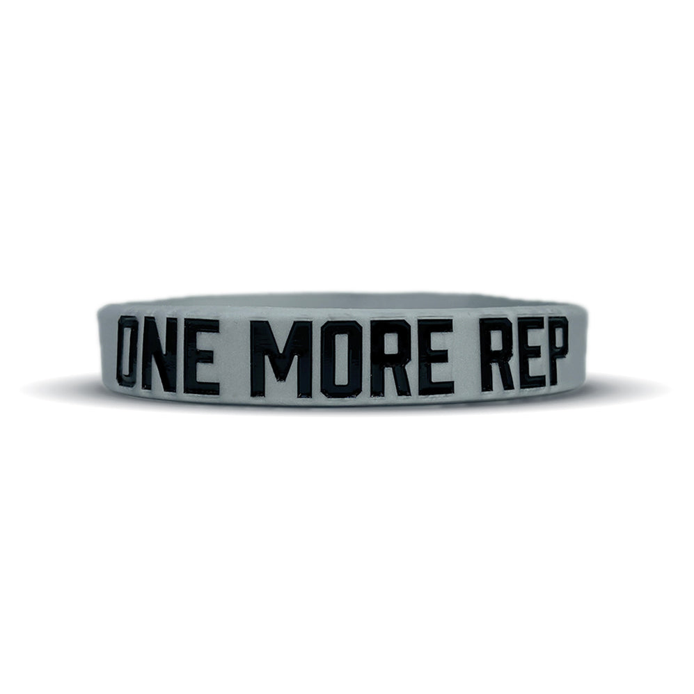 Gray silicone wristband with black debossed lettering reading "ONE MORE REP" around the band.