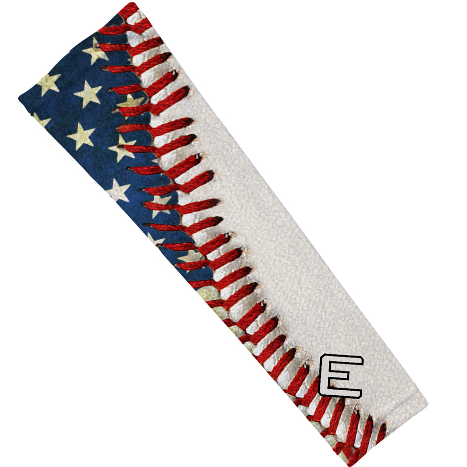 Compression arm sleeve with American flag baseball design, featuring red and white stripes, blue section with gold stars, and sample letter "E" printed on the lower forearm.