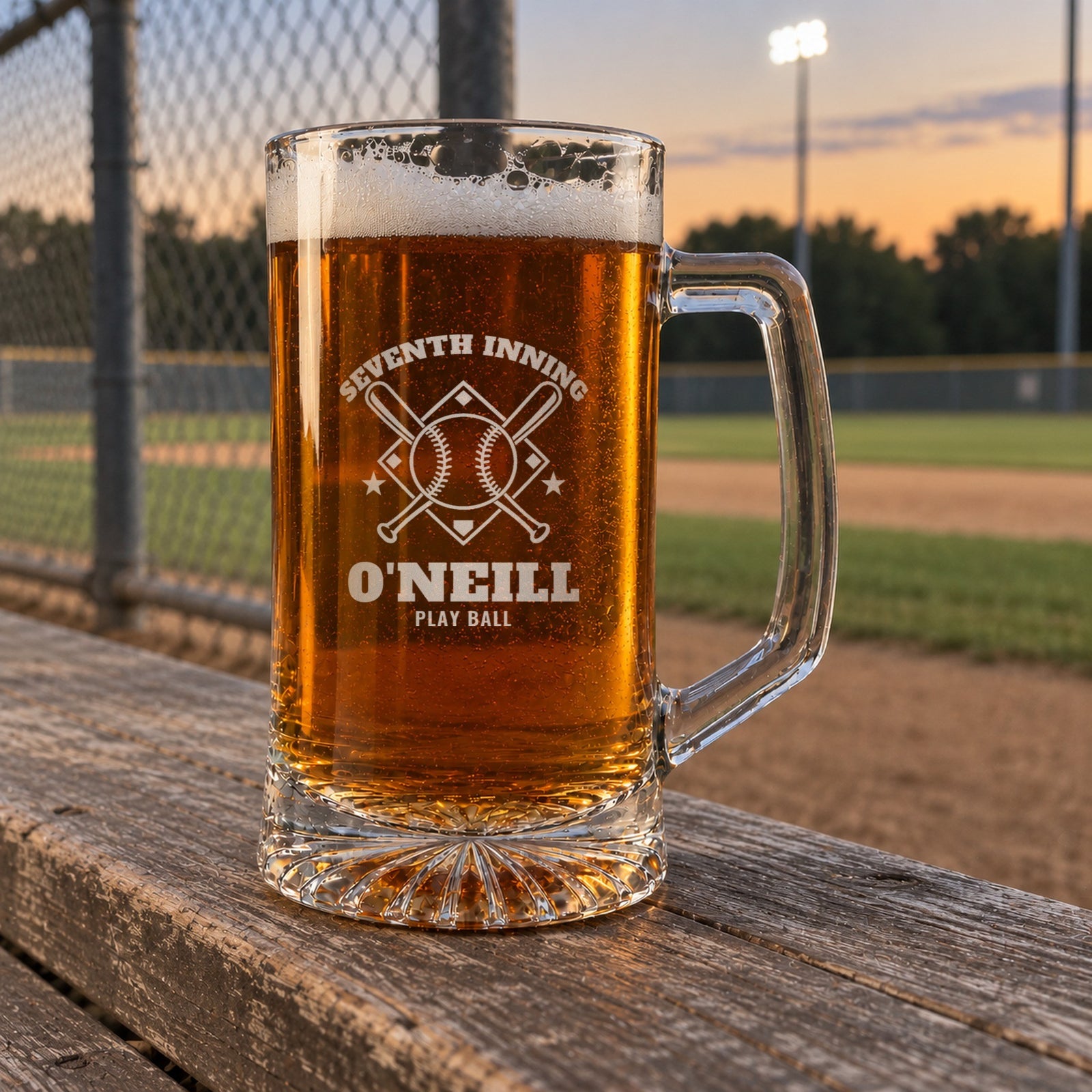Personalized baseball fan beer stein on a ballfield bench at dusk, engraved with crossed bats and a baseball: Seventh Inning, O'Neill, Play Ball