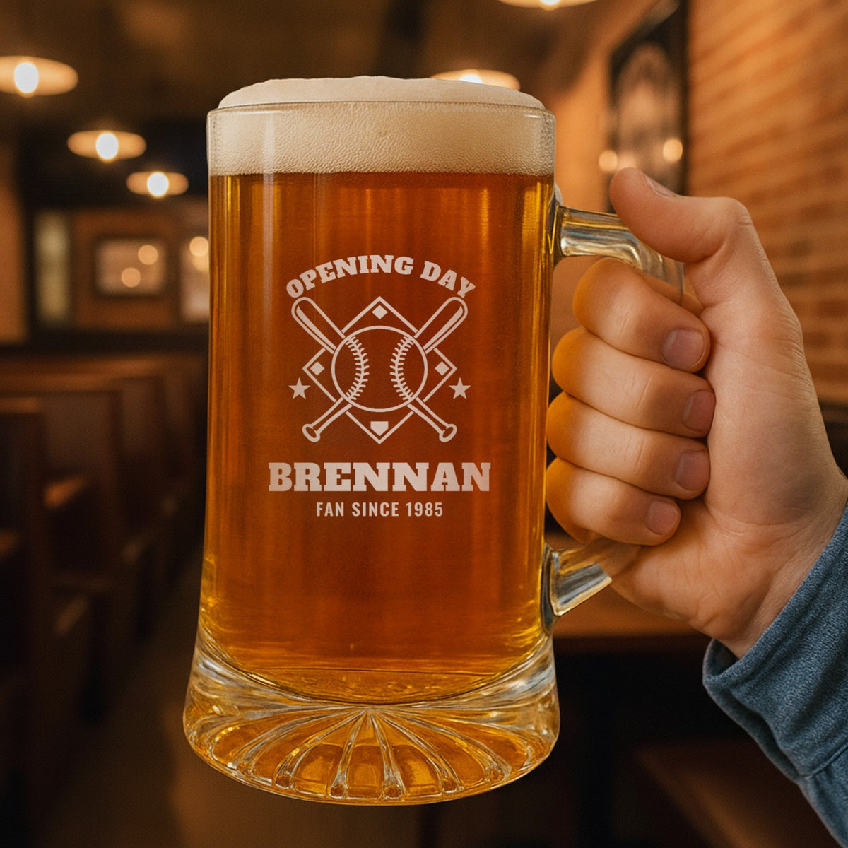 Hand holding the 25 oz personalized baseball dad beer stein in a pub, engraved with crossed bats, a baseball and a diamond: Opening Day, Brennan, Fan Since 1985