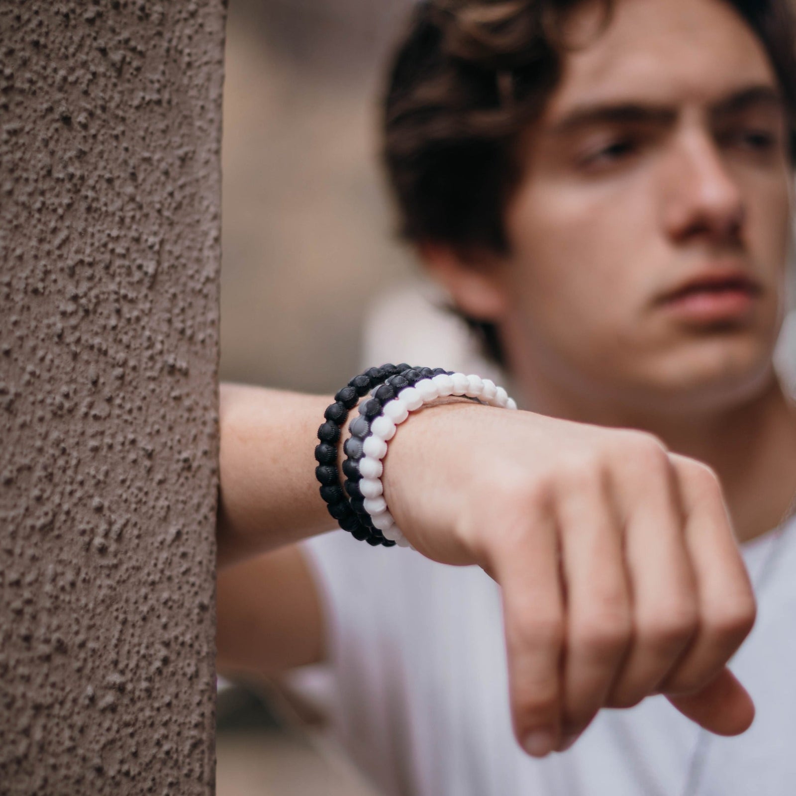 Black and grey baseball bracelet with cross bead, durable silicone design.
