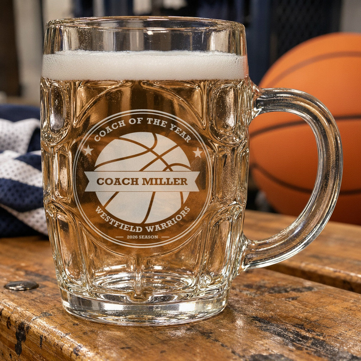 Personalized basketball coach beer stein beside an orange basketball, frosted engraving reading Coach of the Year, Coach Miller and Westfield Warriors