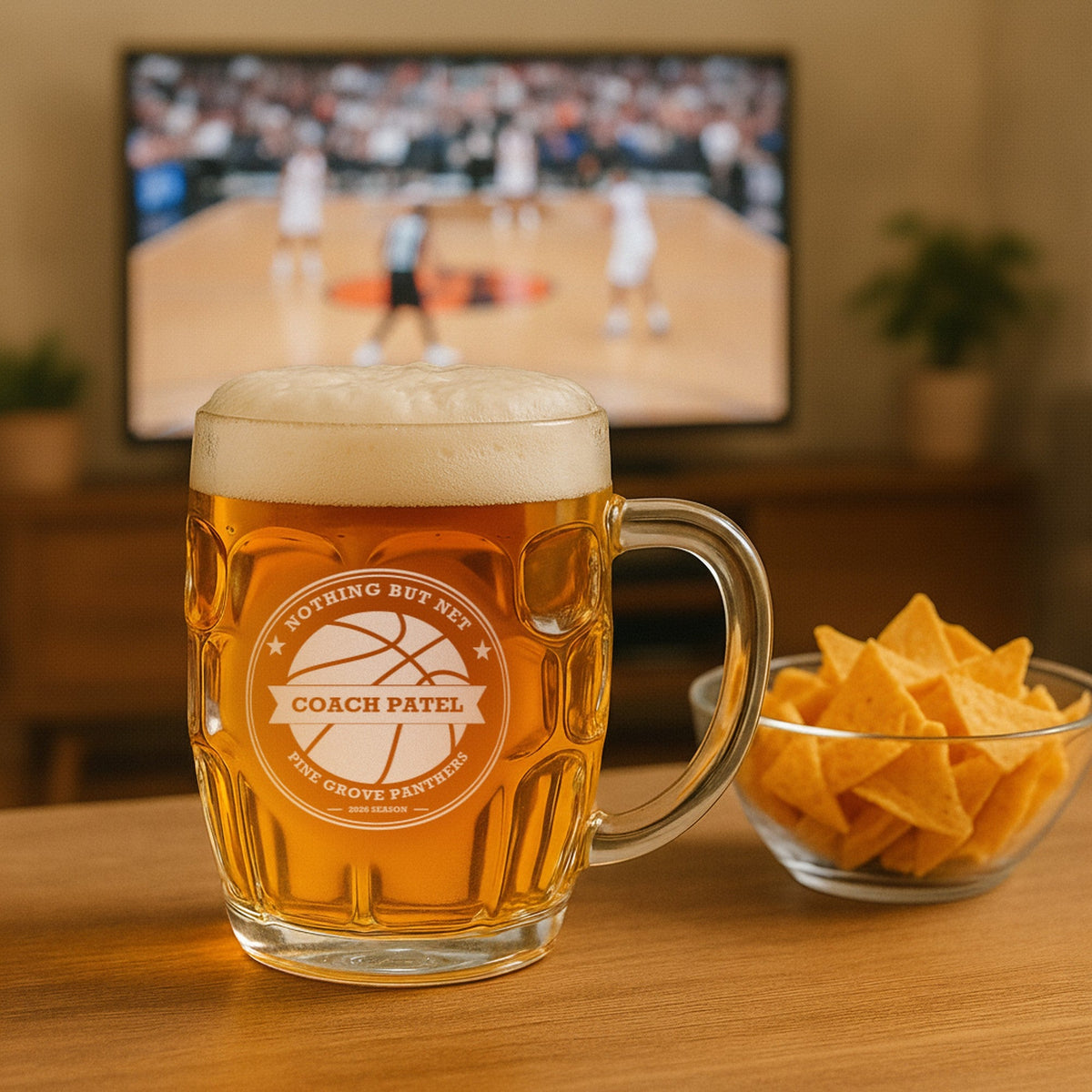 Basketball coach beer stein engraved Nothing but Net for Coach Patel of Pine Grove Panthers, on a table with a basketball game on TV