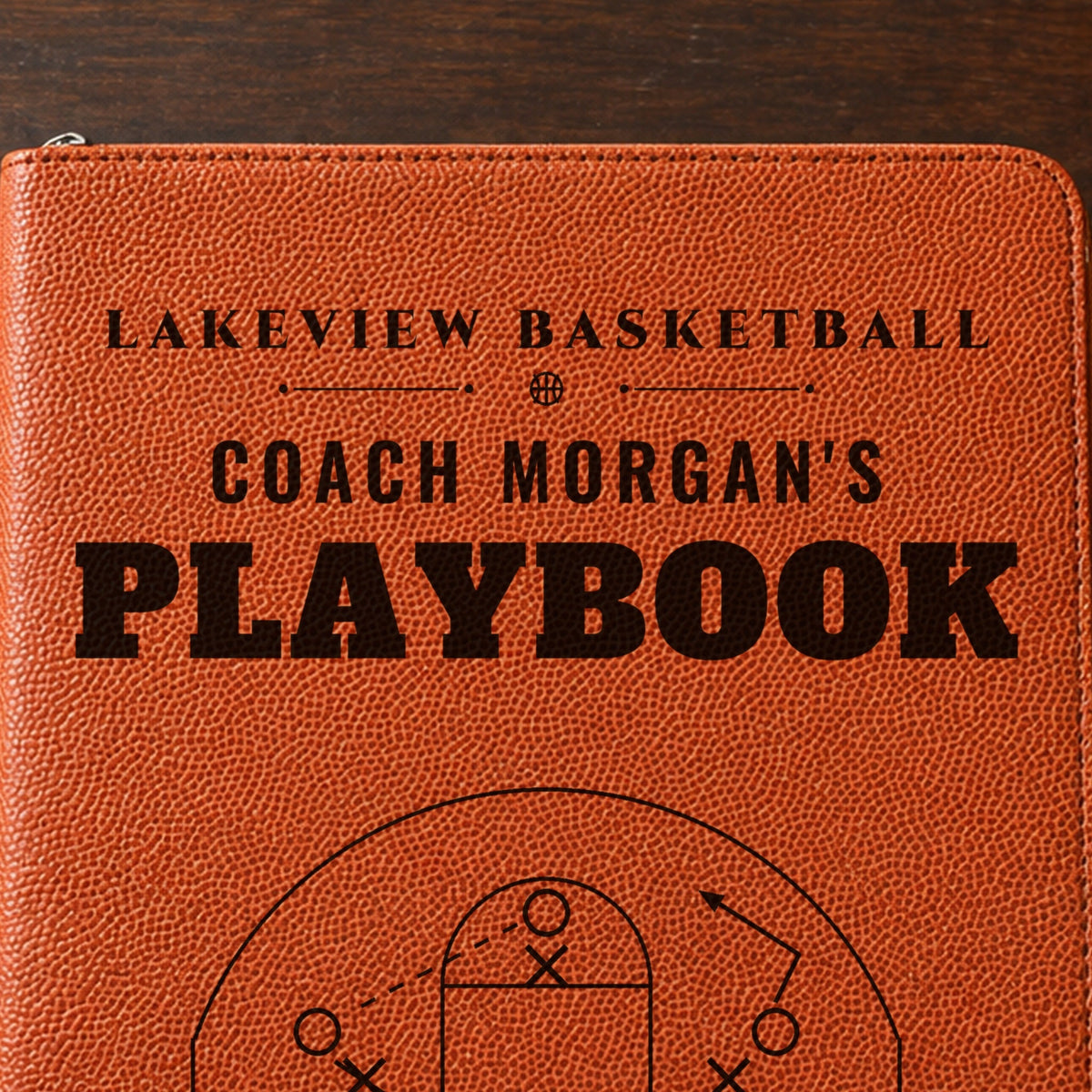 Close-up of the black laser engraving on the basketball grain cover: Lakeview Basketball, Coach Morgan's Playbook and the half-court play diagram