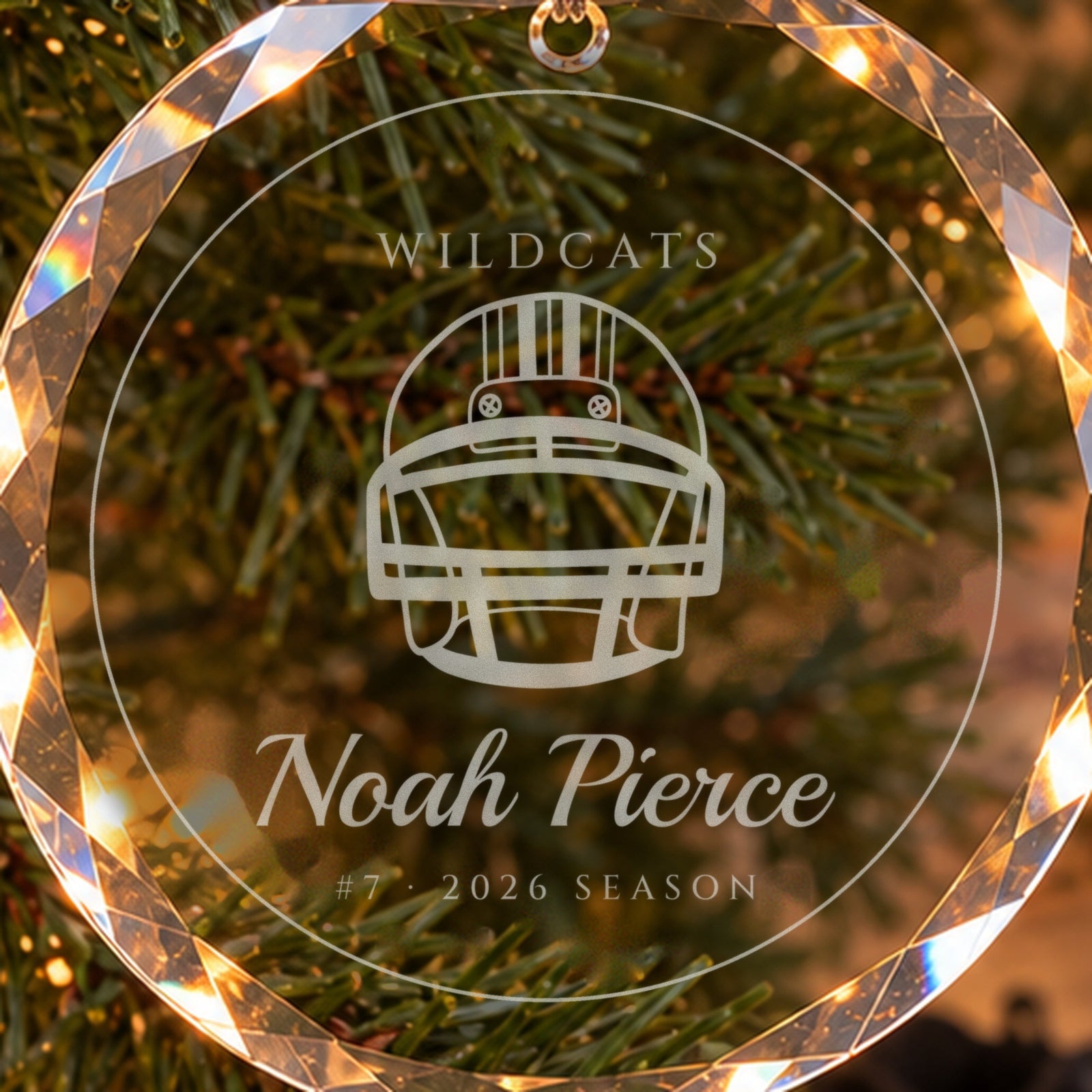 Close-up of the frosted engraving on the football ornament: a football helmet, WILDCATS, Noah Pierce, #7 · 2026 SEASON