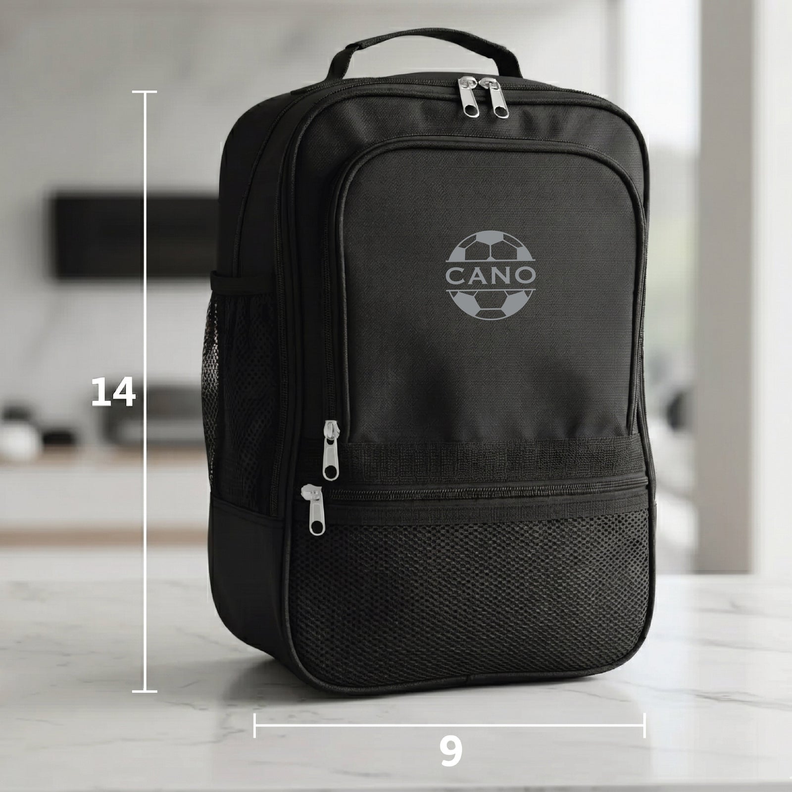 Black duffle bag with sample engraving "CANO" and soccer ball design, showing dimensions 14 inches tall by 9 inches wide
