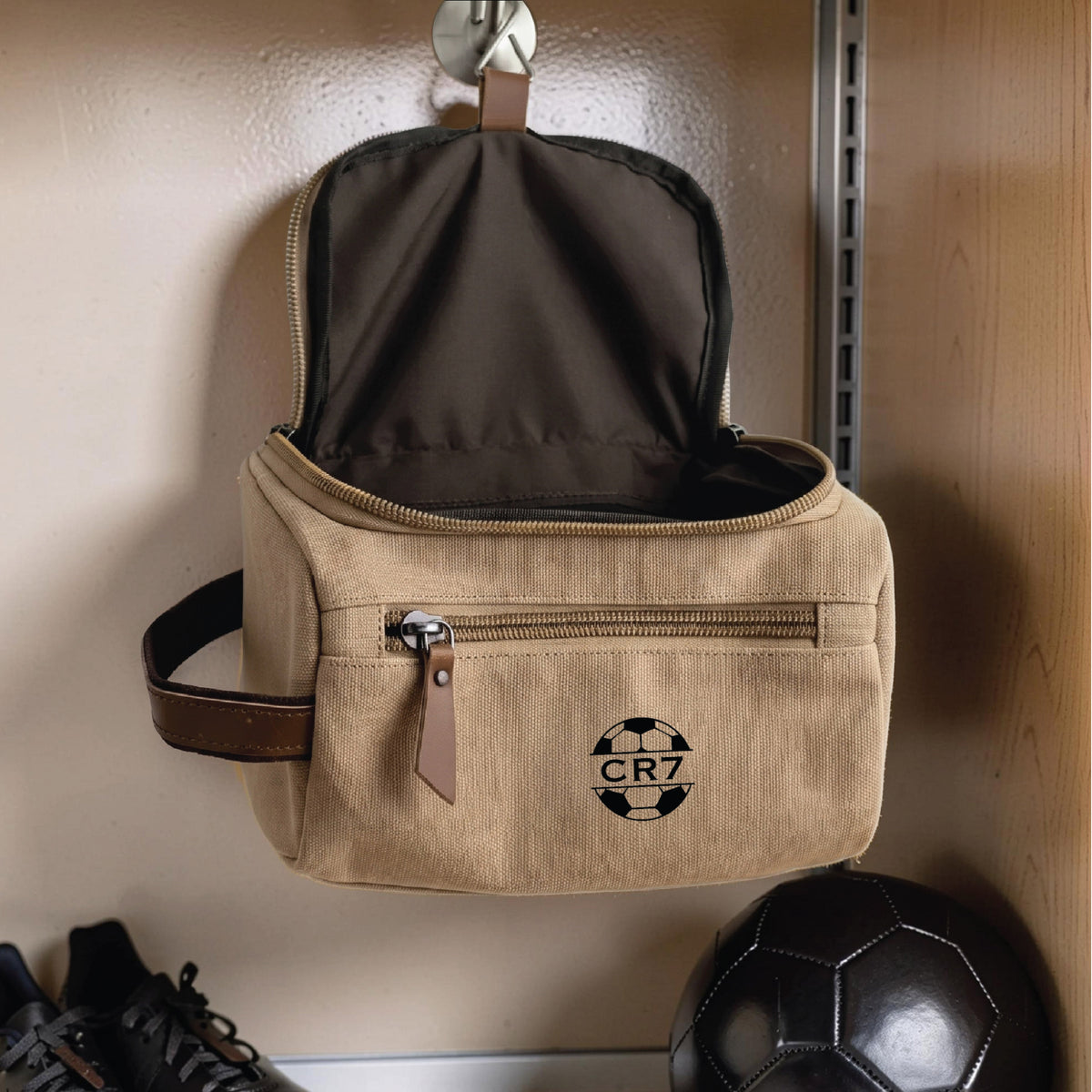 Personalized soccer toiletry bag in washed canvas with a leather handle and an embroidered soccer ball with custom initials, built for road games and college