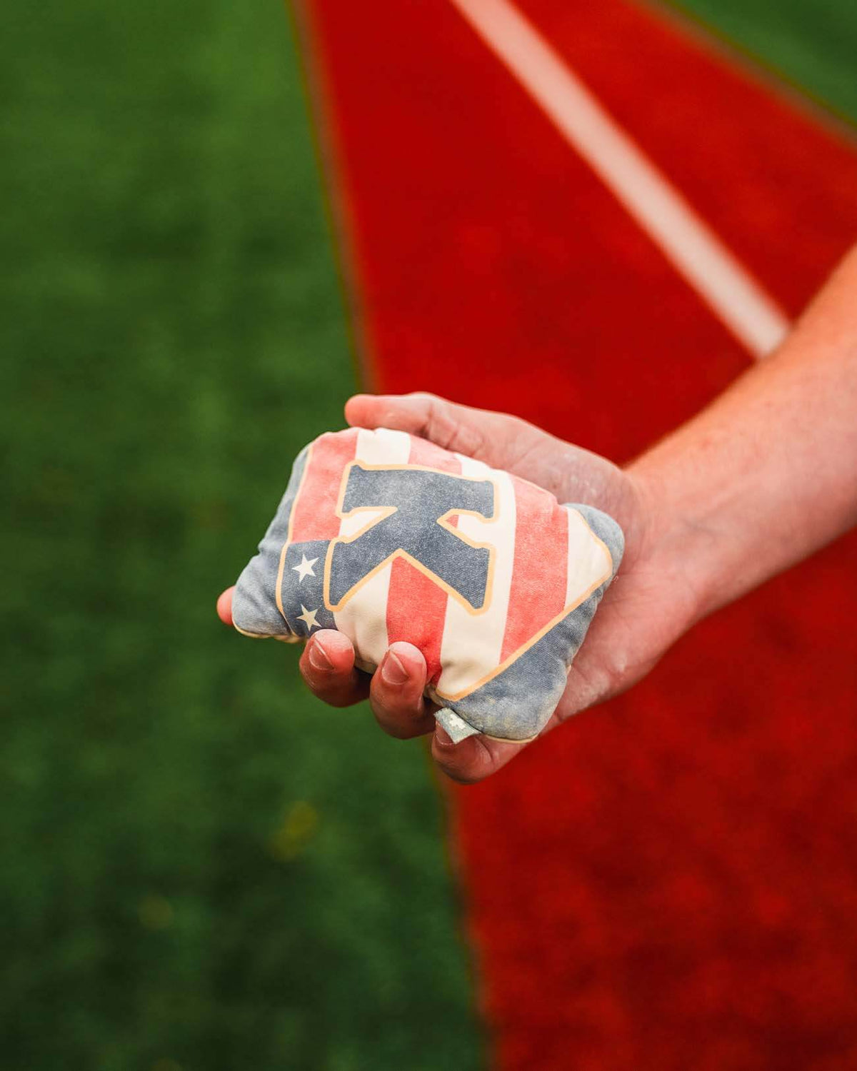 Rosin bag held in hand showing red, white, and blue star pattern design with gray and cream colored sections